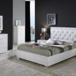 Kombinácia tmavých stien a bieleho nábytku v spálni