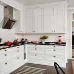 Móveis de cozinha brancos com bancadas escuras