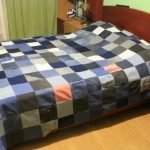 Pătură întinsă din blugi pe pat