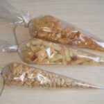 Gießen Sie Erdnüsse und Pommes in Säcke